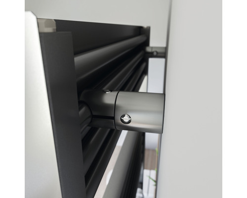 Detailweergave van een gemonteerde radiator aan een muur.