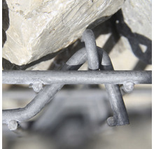 Close-up van een schanskorfconstructie met stenen en metalen raster