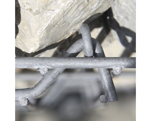 Close-up van een schanskorfmuur met stenen en een draadgaas