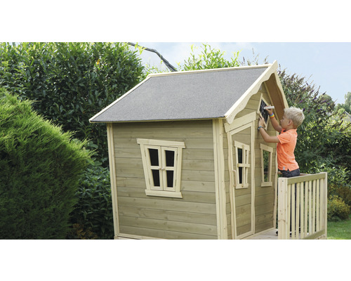 Kind tekent op een houten speelhuis in de tuin