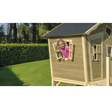 Kind speelt in een houten speelhuis in de tuin
