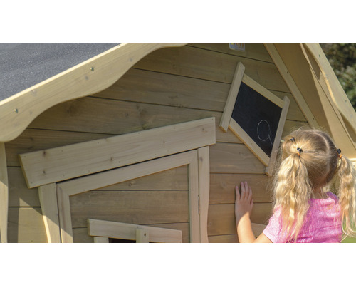 Kind tekent op een schoolbord op een houten speelhuis
