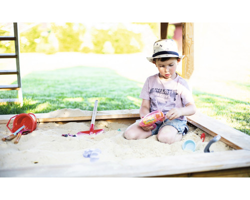 Jonge speelt met speelgoed in de zandbak