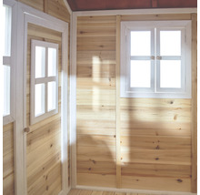 Binnenaanzicht van een houten speelhuis met raam en deur