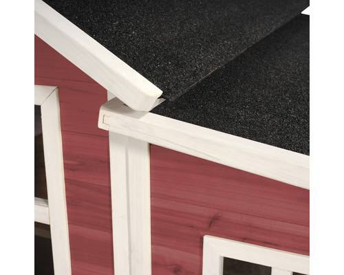 Detailopname van een houten speelhuis met dakleer en witte sierlijsten.