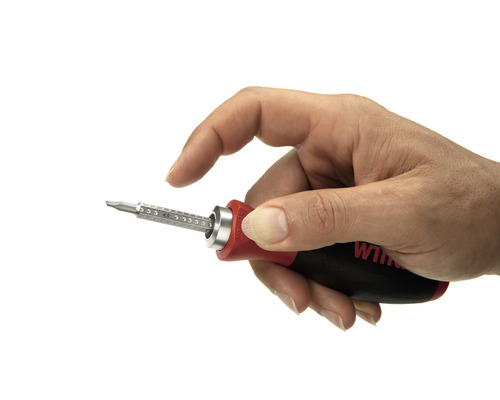 Hand houdt schroevendraaier met verwisselbare bits vast