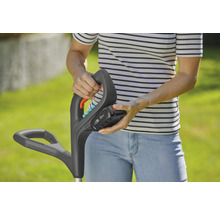 Een persoon bevestigt een accu aan een grastrimmer.