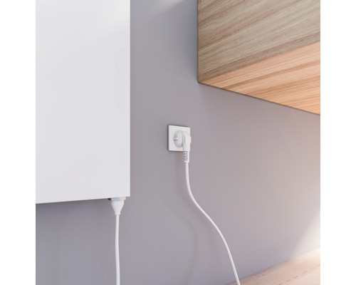 Gedetailleerde opname van een aan de muur gemonteerde radiator met stekker in het stopcontact