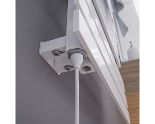 Detailopname van een radiatorbevestiging met kabel aan een muur.