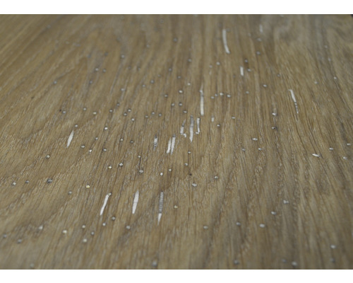 Close-up van een houten oppervlak met nerf en kleine beschadigingen.