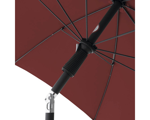 Detailweergave van een open, rode parasol met zwart frame en slinger mechanisme.