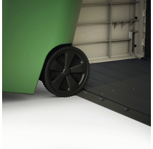 Detailopname van een groene afvalcontainer met zwart wiel en oprit