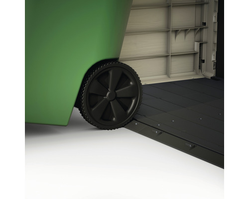 Detailopname van een groene afvalcontainer met zwart wiel en oprit