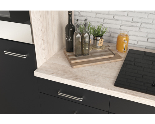 Keukenhoek met houten werkblad, flessen, snijplanken en kookplaat