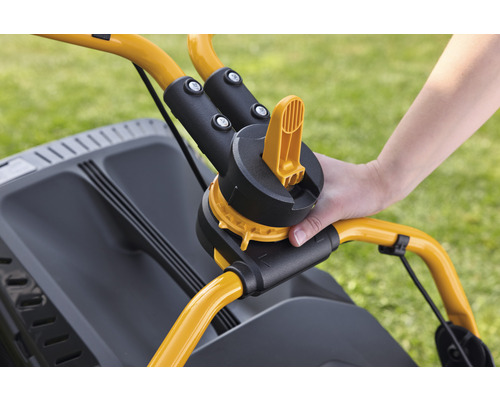 Detailweergave van een gazonmaaier met een hand op de handgreep voor hoogteverstelling.