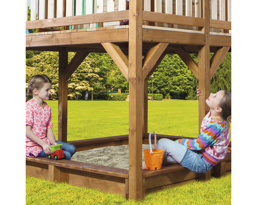 Speeltoren met zandbak en spelende kinderen in de tuin.