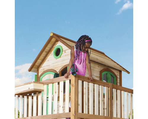 Meisje op een houten speeltoren met huis