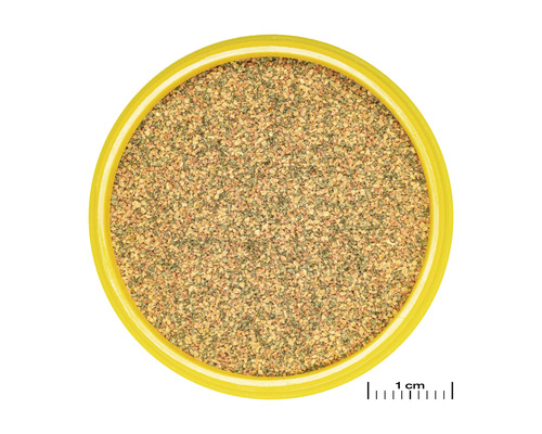 Bovenaanzicht van vogelzand in een gele bak