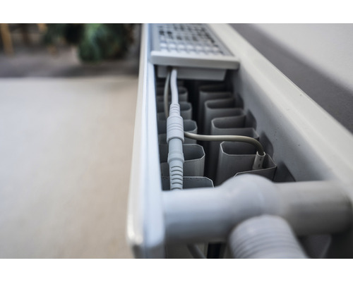 Close-up van een radiator met kabelaansluiting