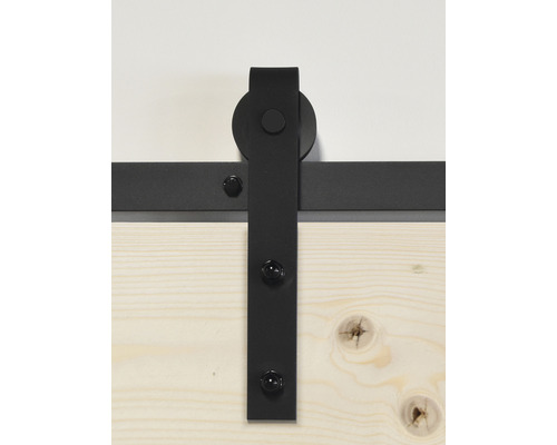 Schuifdeurbeslag van zwart metaal op houten deur