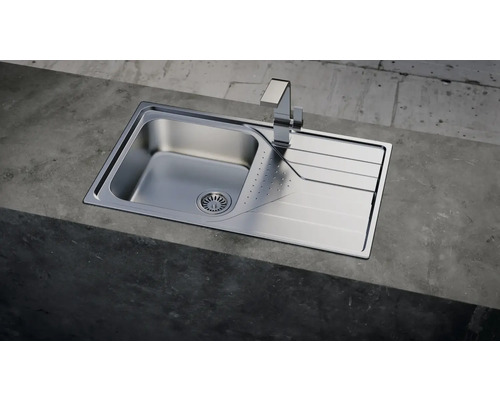 Roestvrijstalen spoelbak met afdruiprek en kraan op een werkblad