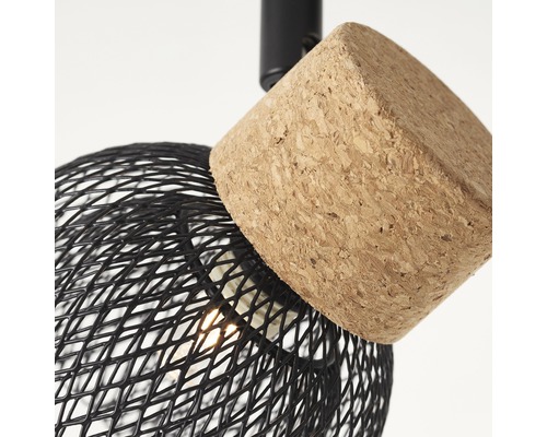 Detailopname van een plafondlamp met zwarte draadkap en kurkelement.