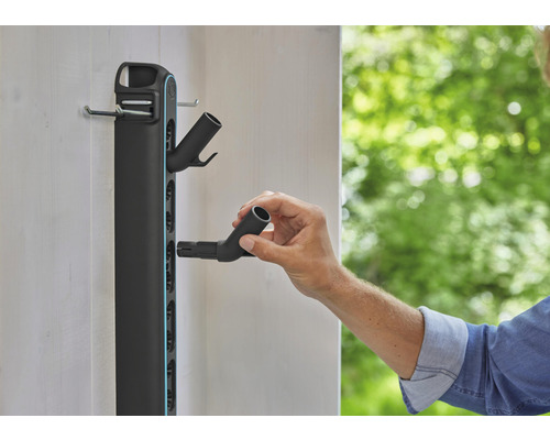 Tuinslanghouder met accessoires wordt aan de wand bevestigd