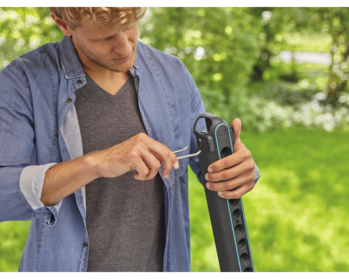 Man monteert een tuindouche buiten.