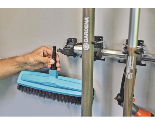 Tuinbezem met steelhouder aan een metalen rail