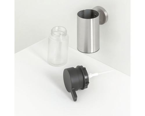 Wandzeepdispenser met lege glazen container en doseerkop