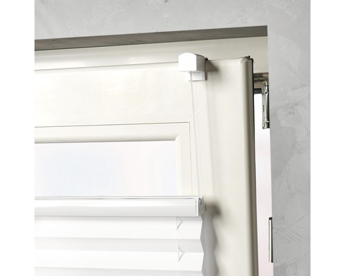 Detailopname van een witte plisségordijn op het raam