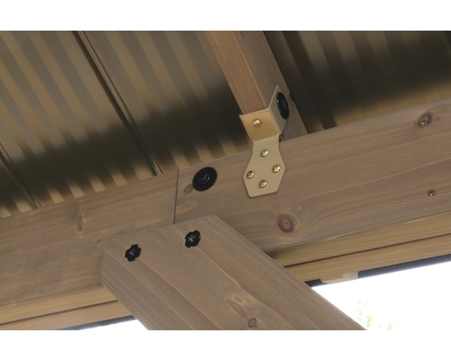 Detail van de houten constructie van een tuinhuis met metalen hoek en schroeven