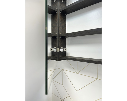 Detailopname van een hoekspiegelkast met planken en scharnieren