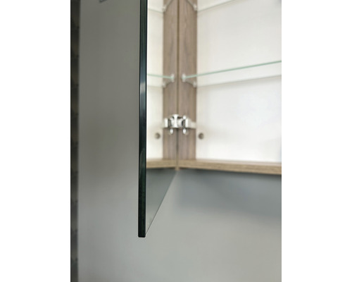 Detailopname van een spiegelkast met glazen planken