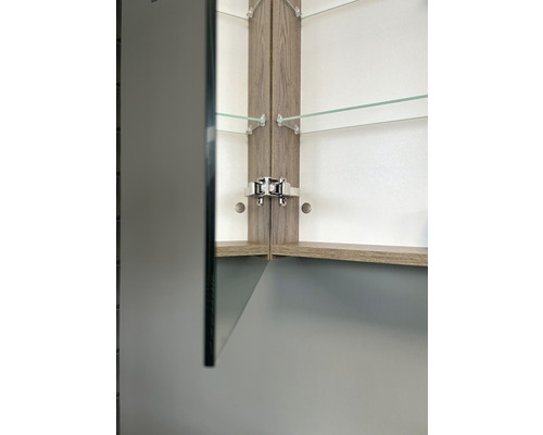 Gedetailleerd beeld van een spiegelkast met houten elementen en glazen planken