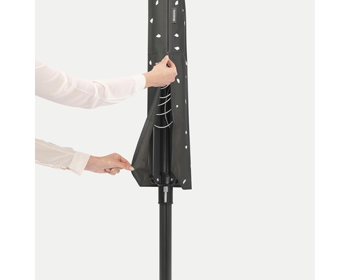 Persoon opent de beschermhoes voor een wasdroogrek