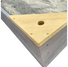 Detailopname van een driehoekige zandbak van hout met een boring