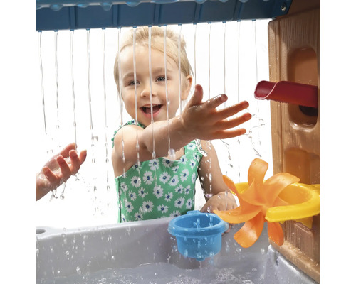 Meisje speelt met een waterspeeltafel met waterrad