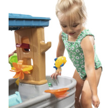 Meisje speelt met een waterspeeltafel in de tuin