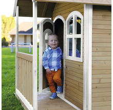 Kind in een houten speelhuis in de tuin