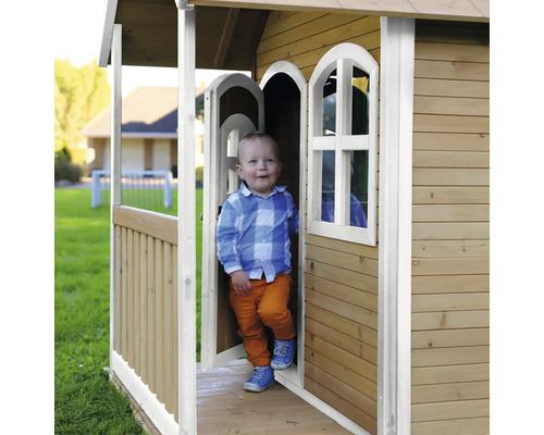 Kind in een houten speelhuis in de tuin