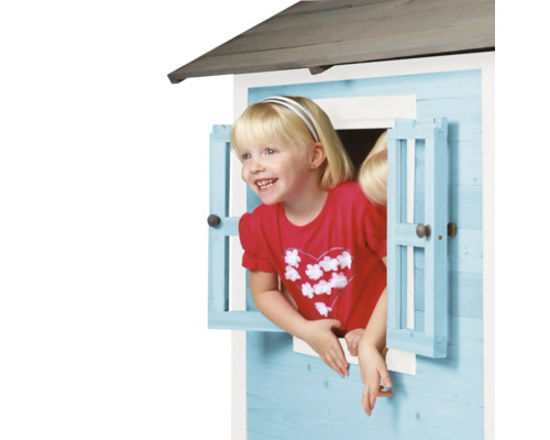 Meisje kijkt uit het raam van een speelhuis