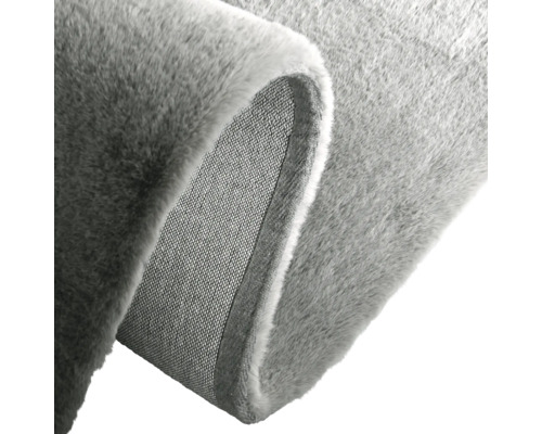 Detailweergave van een grijs tapijt met zacht oppervlak en geweven achterkant