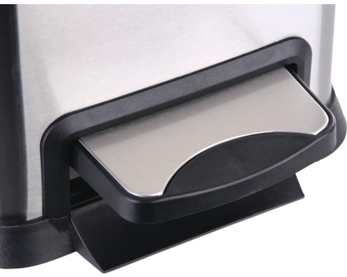 Detailopname van het voetpedaal van een roestvrijstalen pedaalemmer.