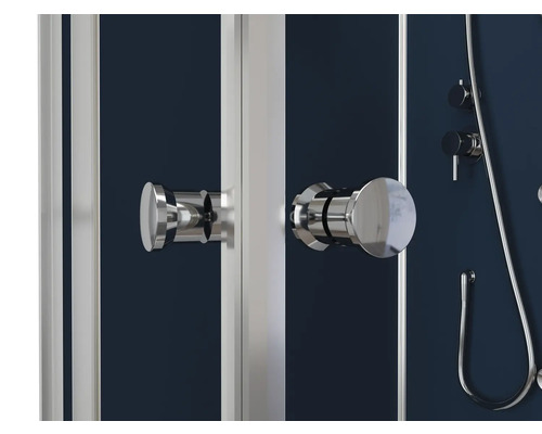 Detailopname van een douchecabine met handgrepen, kranen en doucheslang.