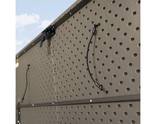 Detailopname van een gereedschapskist met geperforeerde wand voor het opbergen van tuingereedschap.