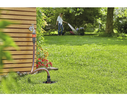 Tuinscene met waterkraan, tuinslang en gazonsproeier voor irrigatie
