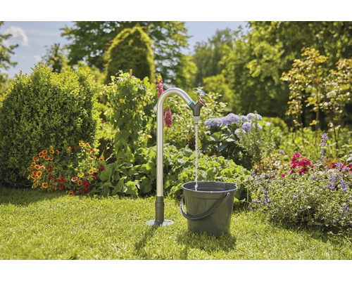 Tuinscene met waterkraan en emmer op gazon