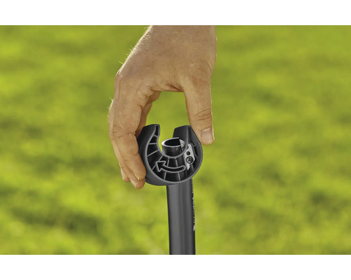 Hand houdt opzetstuk voor grastrimmer vast