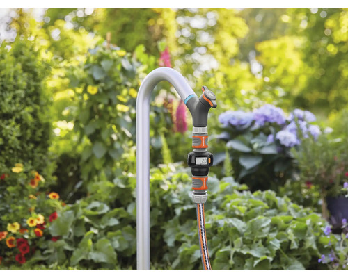 Tuinscene met kraan, slang en digitale watermeter in de tuin